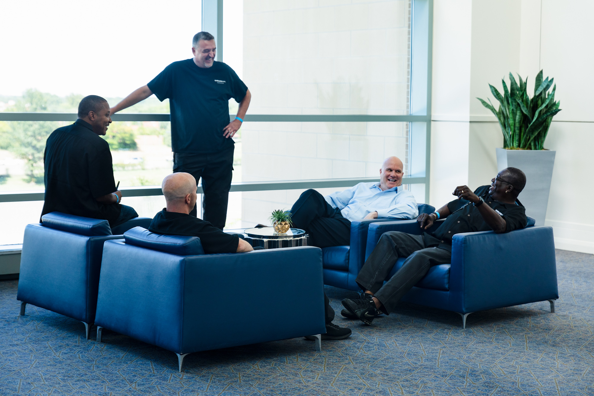 Men smile as they discuss the best methods for measuring outcomes of events.