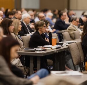 A woman listens intently at a speaking event that we discuss in our keynote speakers spotlight