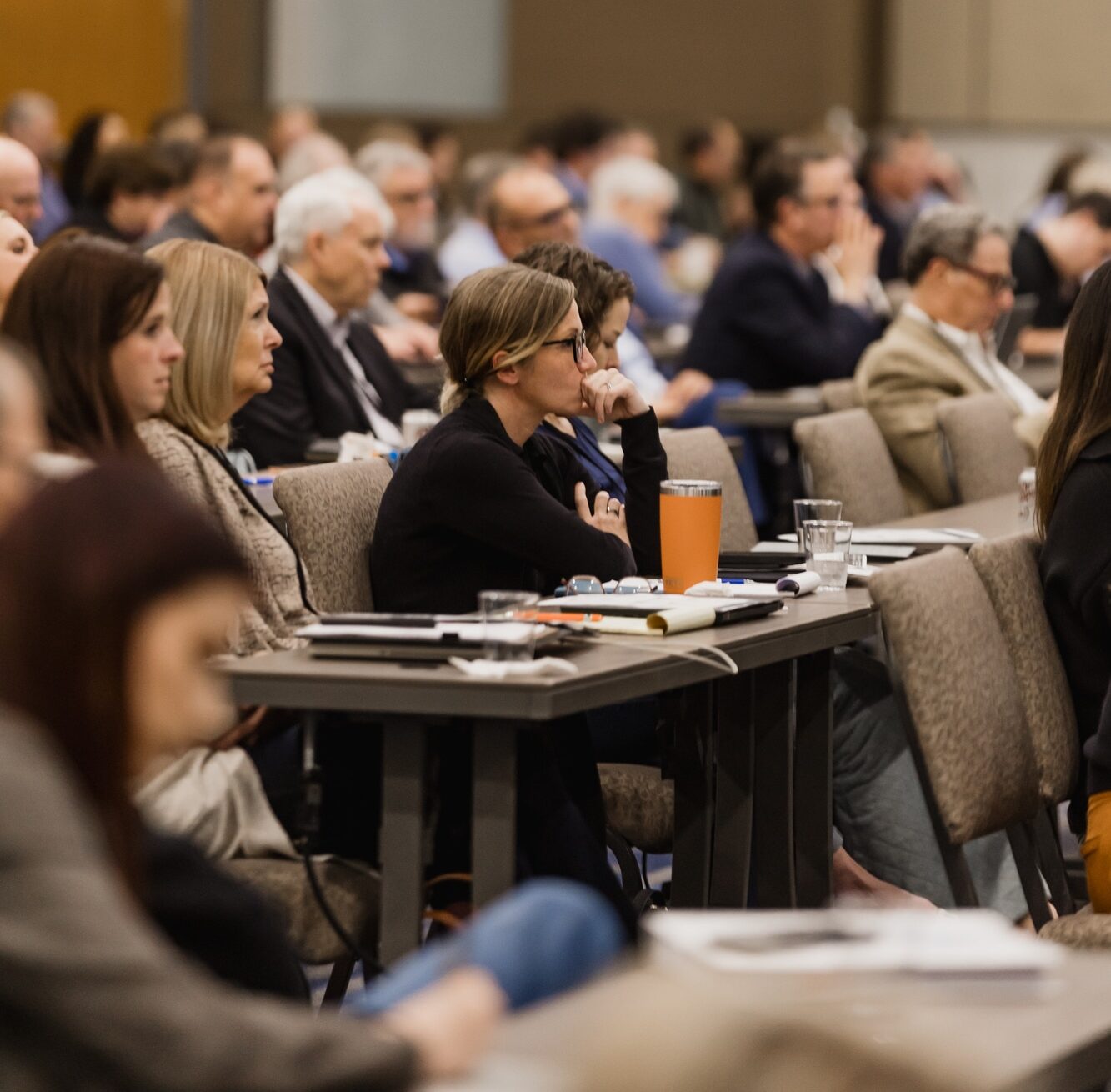 A woman listens intently at a speaking event that we discuss in our keynote speakers spotlight